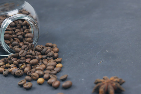 roasted coffee beans poured from a glass jar. angular placement of the coffee object.の写真素材