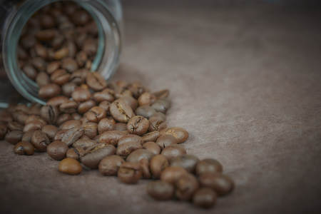 roasted coffee beans poured from a glass jar. angular placement of the coffee object.の写真素材