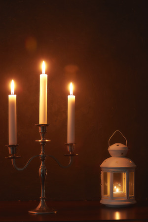 quiet home environment at night by candlelight. White candles burn in the dark.の写真素材