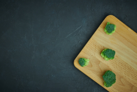 placer green broccoli segments from a small bucket. Healthy eating pattern on dark background. Copy space Top view. Vegetarian food.の写真素材