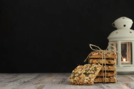 A stack of shortbread cookies with different types of nuts to a delicious coffee or tea on a dark wood table. horizontal view.の写真素材
