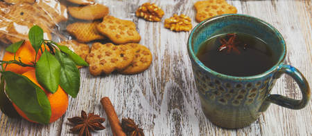 ceramic Cup of black tea with a handful of cookies with nuts on a white, old, shabby wooden table, vertical view. the composition of the morning Breakfast with cookies.の写真素材