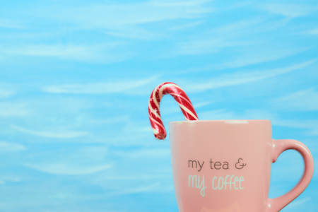 Pink Cup on blue background with coffee text. Horizontal view, copy space, pastel colors.の写真素材