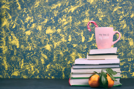 Still life with books in color covers and a pink mug with the inscription coffee. horizontal Vit. copy space. place for text. school subjects.の写真素材