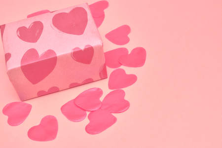 Gift in Kraft paper with red hearts on pink background with hearts. The Concept Of Valentine's Day.の写真素材