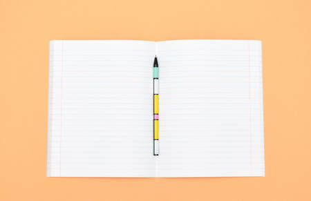 Notebook, pen and colored numbers on orange background. Accessories for study. Mathematics,, flat, copy spaceの写真素材