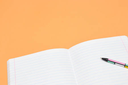 Notebook, pen and colored numbers on orange background. Accessories for study. Mathematics,, flat, copy spaceの写真素材