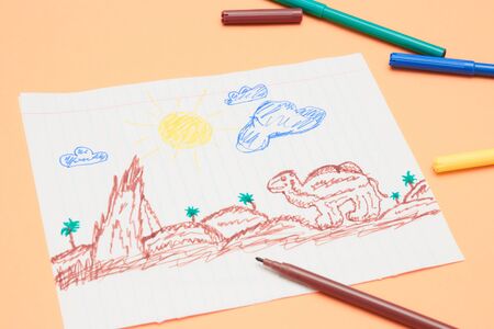 Next to the markers is a primitive children's drawing with a felt-tip pen on a peach background....