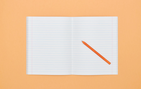 Blank Notepad with pen on orange peach color background. The View From The Top. school subjects and education. white sheet in notebook.の写真素材