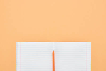 Notebook, pen and colored numbers on orange background. Accessories for study. Mathematics,, flat, copy spaceの写真素材