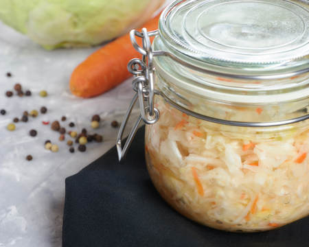 Home sauerkraut with salad in a glass jar. vertical view, close-up.の写真素材