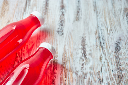 Plastic soda bottle berry juice drink on wooden background. a couple of gallons of refreshing berry drink. the view from the top. copy space.の写真素材