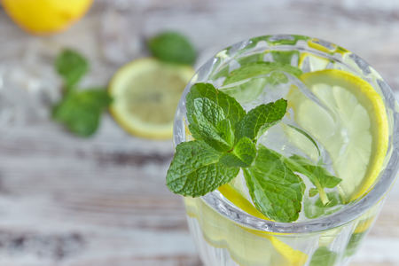A glass of cool water with ice, lemon and mint. Selective focus. refreshing summer drink. large.の写真素材