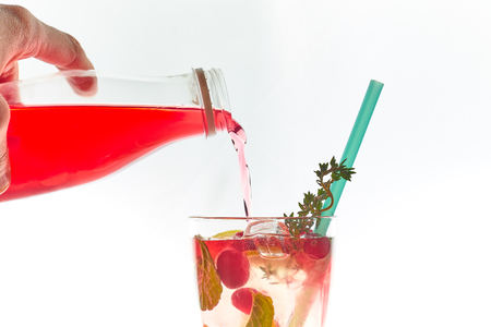 Cold mint berry cocktail in a sling isolated on white. copy space. summer refreshing drink with a straw.の写真素材