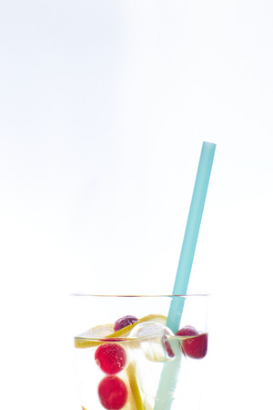 Cold mint berry cocktail in a sling isolated on white. copy space. summer refreshing drink with a straw.の写真素材