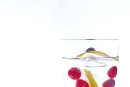 cold Summer refreshing cocktail with lemon pieces of ice and berries. photo summer drink close-upの写真素材