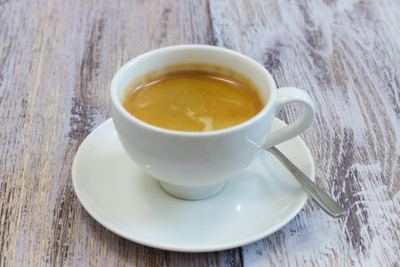 white Cup of coffee on a wooden table close-up. black coffee with milk. wooden table with a fragrantの写真素材