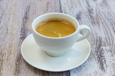white Cup of coffee on a wooden table close-up. black coffee with milk. wooden table with a fragrantの写真素材