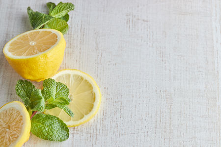 sliced lemon and mint slices on a light wooden background. the view from the top. copy space.
