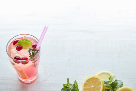 In summer, drink berry lemonade cocktail with lemon and ice in a glass. Ice-cold lemonade. Healthy vitamin drink. Copy space.の写真素材