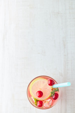 In summer, drink berry lemonade cocktail with lemon and ice in a glass. Ice-cold lemonade. Healthy vitamin drink. Copy space.の写真素材