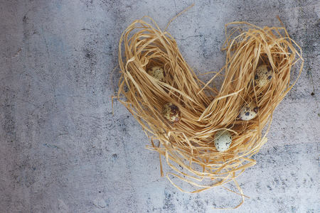 raw quail eggs in hay. country style. group of fresh quail eggs on light concrete.の写真素材