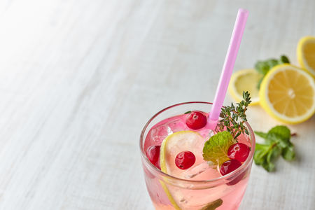 Refreshing summer drink with berry and lemon on a light wooden table. The concept of summer drinks with ice. glass with summer cocktail withの写真素材