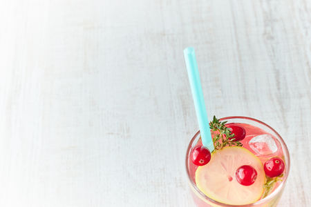 Refreshing summer drink with berry and lemon on a light wooden table. The concept of summer drinks with ice. glass with summer cocktail withの写真素材