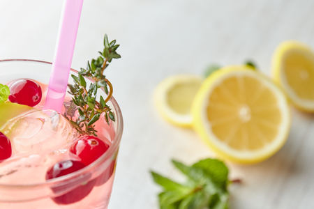 Lemonade with ice and fresh lemon with mint on wooden background. horizontal view. copy space. refreshing summer drink.の写真素材