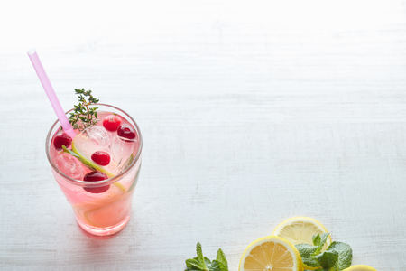 Lemonade with ice and fresh lemon with mint on wooden background. horizontal view. copy space. refreshing summer drink.の写真素材