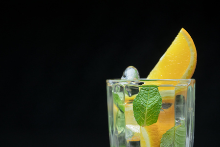 Healthy detox water with orange and mint. Close up of a refreshing summer drink on black background. citrusの写真素材