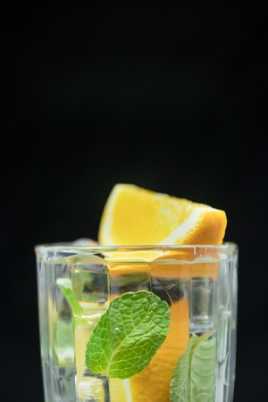 Healthy detox water with orange and mint. Close up of a refreshing summer drink on black background. citrusの写真素材