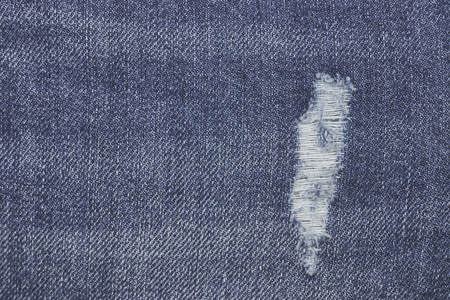 Denim ripped blue jeans texture. Abstract background faded jeans.の写真素材