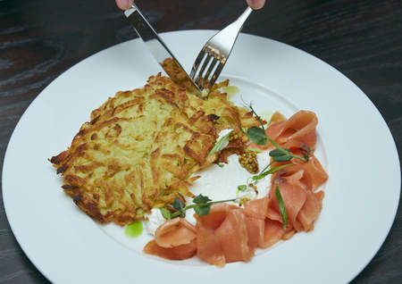 dish Marinated salmon with dill and potato pancakes on a wooden table. fresh salted trout. dish on a plate. Russian food.の写真素材