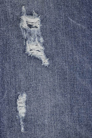 Denim ripped blue jeans texture. Abstract background faded jeans.の写真素材