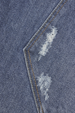 Denim ripped blue jeans texture. Abstract background faded jeans.の写真素材