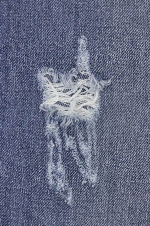 Denim ripped blue jeans texture. Abstract background faded jeans.の写真素材