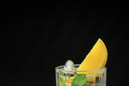Healthy detox water with orange and mint. Close up of a refreshing summer drink on black background. citrusの写真素材