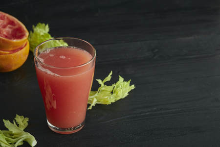 fresh citrus grapefruit juice in a glass. On a black wooden table. Black background. horizontal view.の写真素材