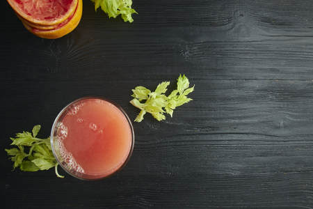 fresh citrus grapefruit juice in a glass. On a black wooden table. Black background. horizontal view.の写真素材
