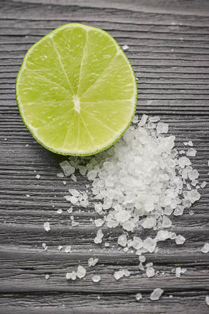 Fresh sliced lime and salt on a wooden table closeup. half lime with salt.の写真素材