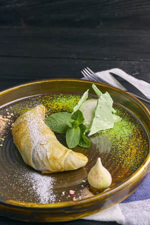 Baked apple strudel with a scoop of vanilla ice cream and meringue on a dark wooden table, closeup. restaurantの写真素材