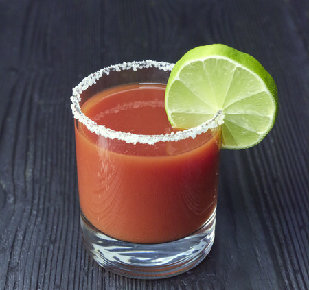 Two mason jar Bloody Marys or Caesars with lemon and lime on wood backgroundの写真素材