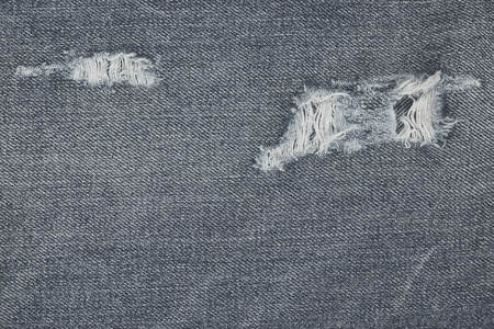 Denim ripped blue jeans texture. Abstract background faded jeans.の写真素材