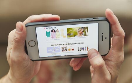 Smartphone online shopping in the hand of a woman. Buy accessories for clothes, shoes with online...