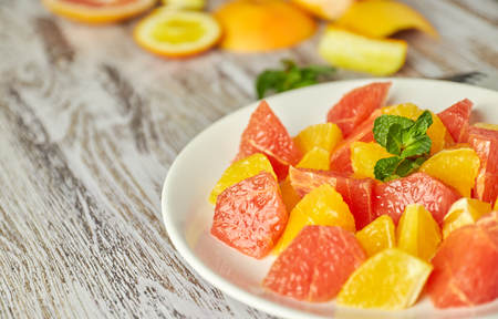 Orange-grapefruit citrus salad on a shabby wooden table. copy space. summer vitamin