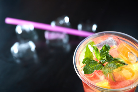 Summer refreshing cocktails with citrus and mint. orange and grapefruit segments. drink on a black table with ice cubes.の写真素材