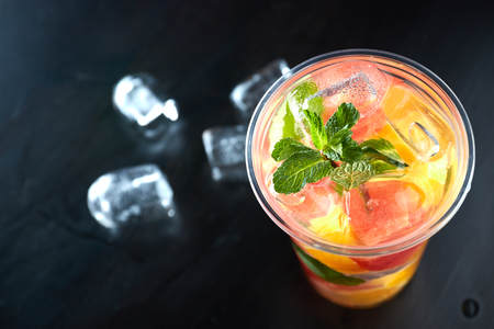 Summer refreshing cocktails with citrus and mint. orange and grapefruit segments. drink on a black...