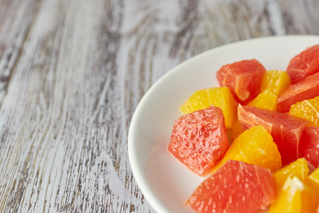 citrus detox salad. colorful tropical and citrus fruits sliced on a plate. country style. copy space.の写真素材