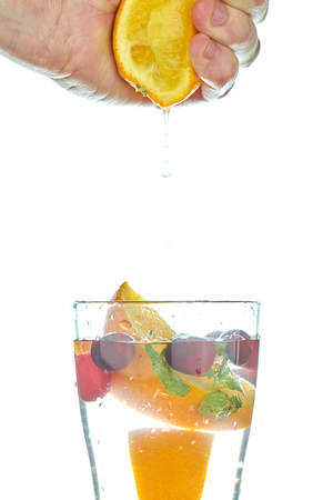 Detox lemonade with orange slices and berries with mint on a white background. refreshing drink.の写真素材